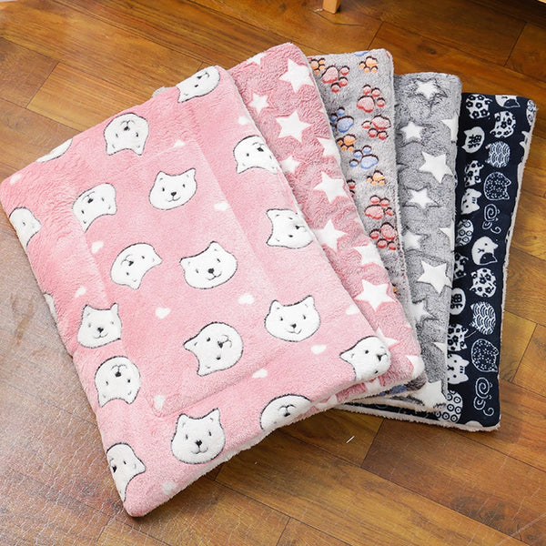 A stack of thick flannel pet mats featuring various patterns and colors for cats and dogs.