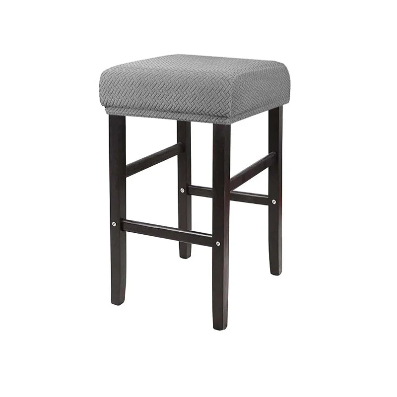 A gray fabric slipcover for a bar stool with dark wooden legs and a padded seat.