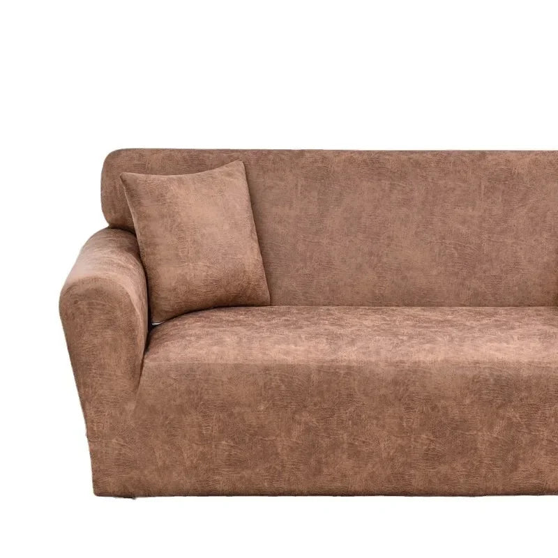 A modern, brown PU leather sofa slipcover with a single throw pillow.