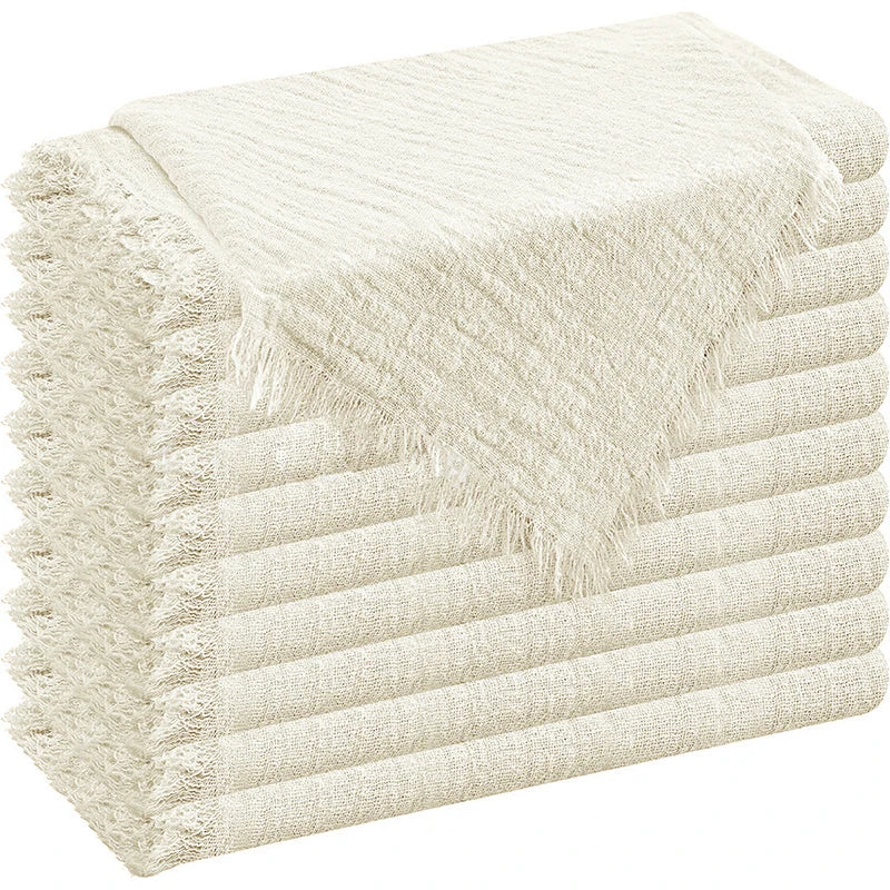 A stack of cream-colored decorative cloth napkins folded neatly.
