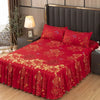 A vibrant red fitted bed sheet set with gold embroidery and lace trim displayed on a bed.