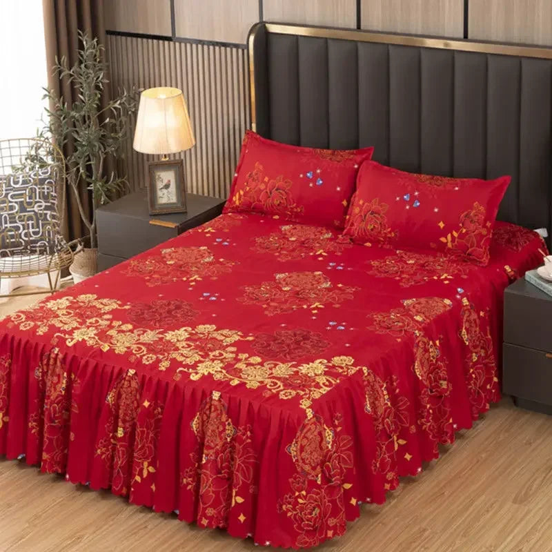 A vibrant red fitted bed sheet set with gold embroidery and lace trim displayed on a bed.