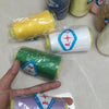 A hand holds several spools of yellow, blue, pink, and green polyester sewing thread.