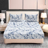 A fitted sheet set with a white and blue marble print is displayed on a bed with a neutral headboard.