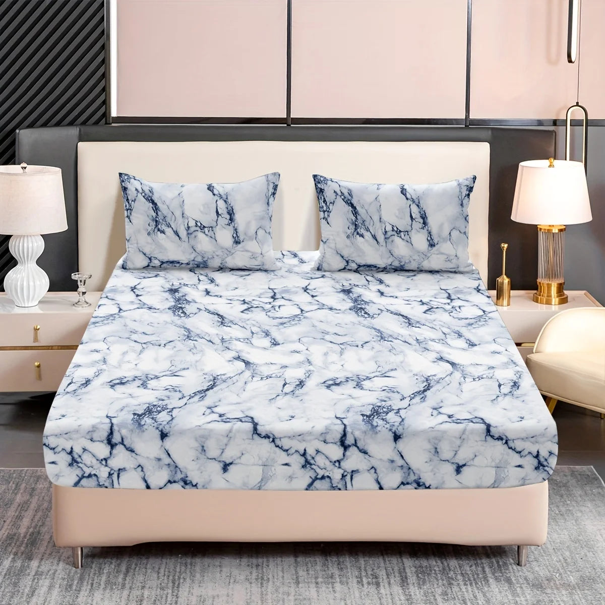 A fitted sheet set with a white and blue marble print is displayed on a bed with a neutral headboard.