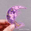 A purple embroidered crescent moon patch featuring a stylized face and yellow stars on pink fabric.