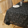 Elegant black lace tablecloth with floral embroidery set for a dining table.