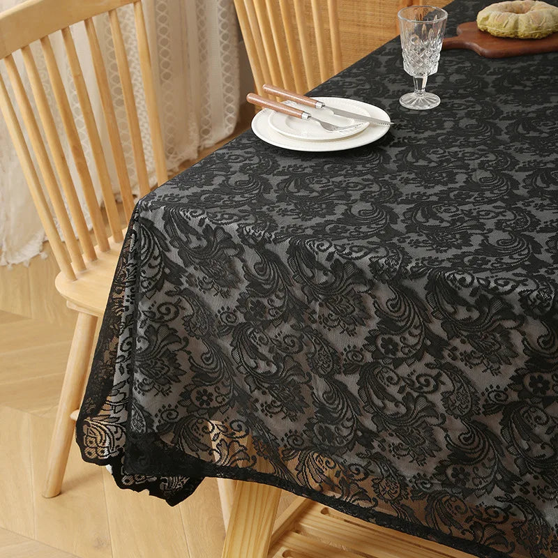 Elegant black lace tablecloth with floral embroidery set for a dining table.