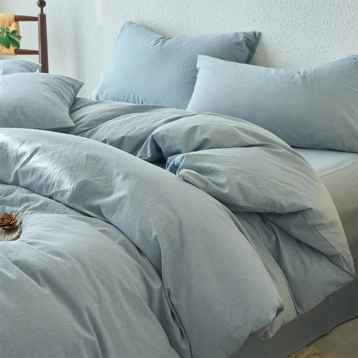 A light blue cotton yarn-dyed duvet cover with matching pillows on a bed.