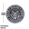 Black embroidered patch featuring a bald eagle, crossed guns, and the word freedom on a circular design.