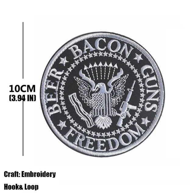 Black embroidered patch featuring a bald eagle, crossed guns, and the word freedom on a circular design.