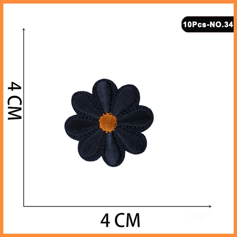 A set of 10 black and orange embroidered iron-on patches shaped like flowers or butterflies.