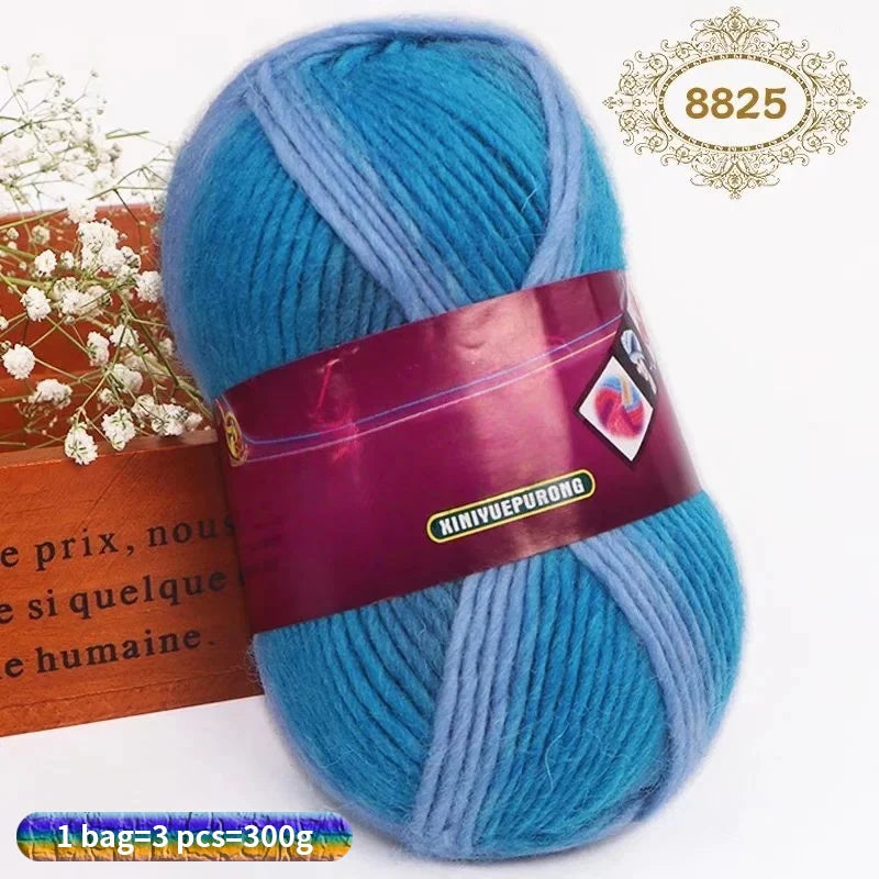 A skein of bright blue and light blue gradient dyed wool yarn is shown next to a wooden box.