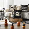 A set of four Halloween cushion covers featuring ghost, pumpkin, and skull designs on black and white fabric.