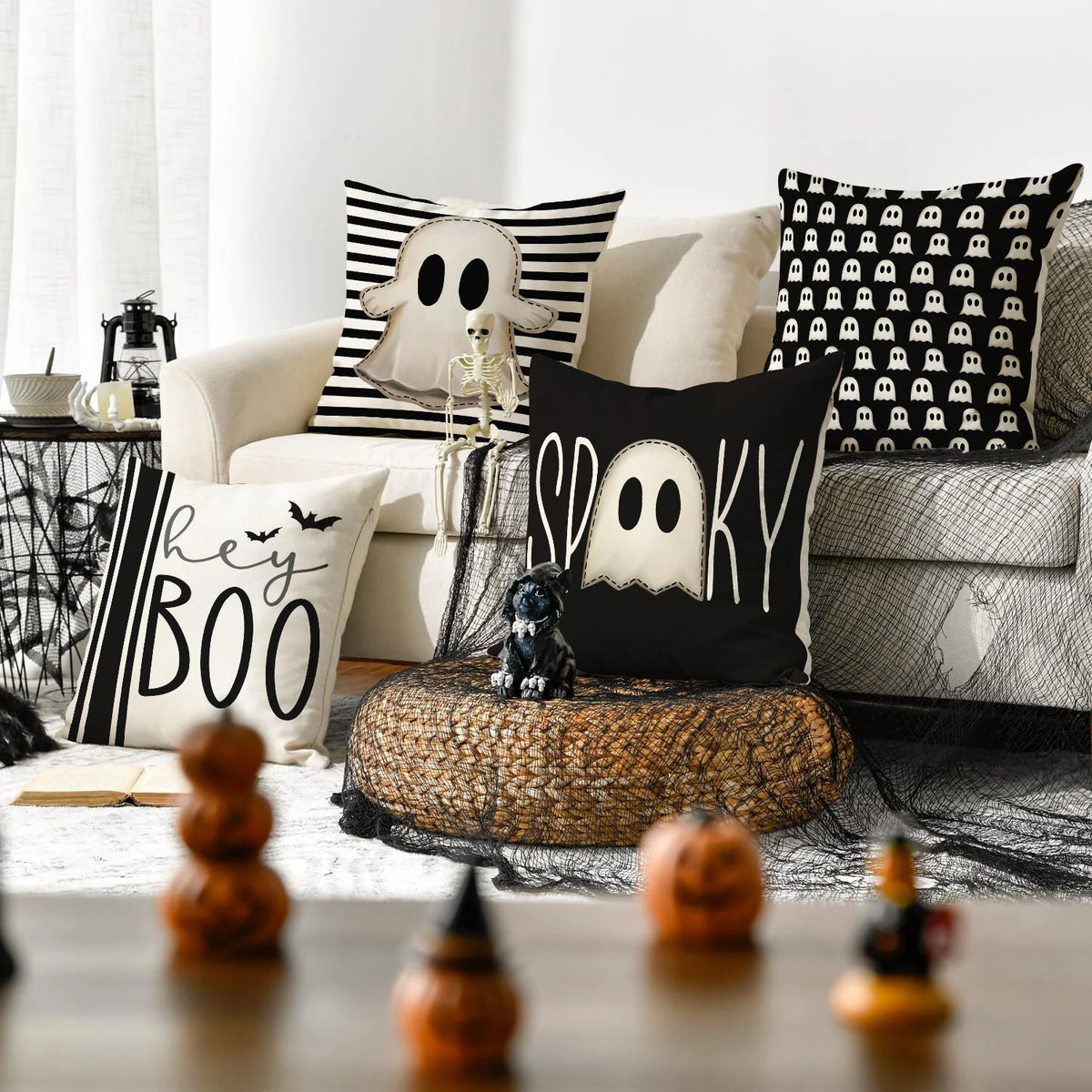 A set of four Halloween cushion covers featuring ghost, pumpkin, and skull designs on black and white fabric.