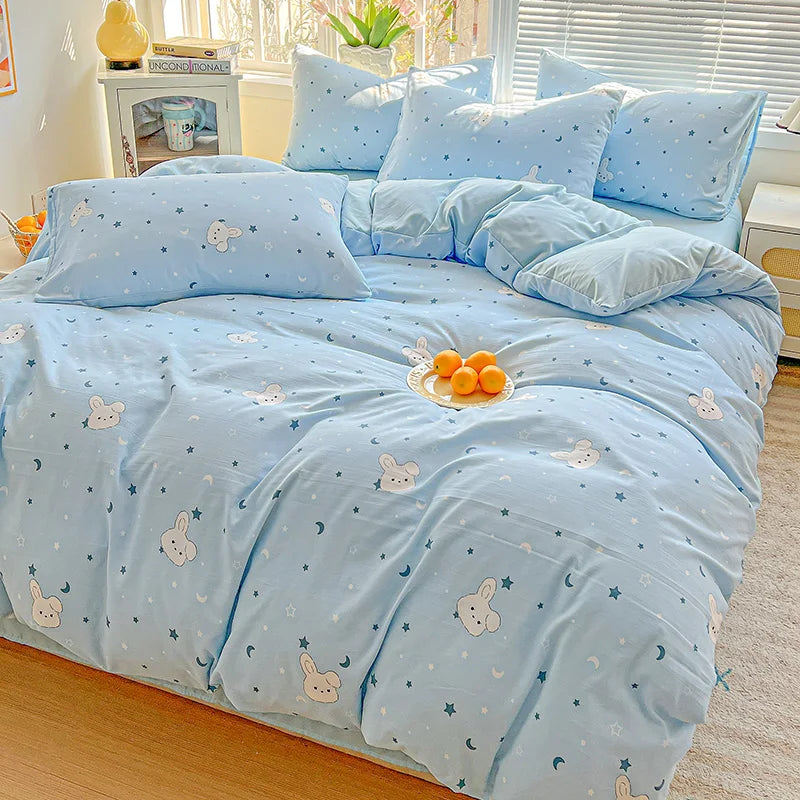 Light blue floral printed bedding set with small white animal patterns on a bed.