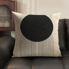 A beige cushion cover with a black geometric line pattern featuring concentric circles and radiating lines.