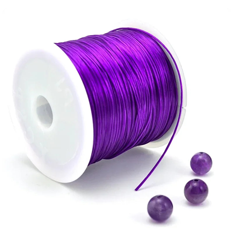 Purple elastic beading cord on a spool with loose strands nearby