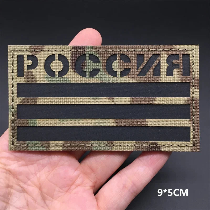 A rectangular tactical patch featuring the Russian flag text and camouflage pattern on a dark background.