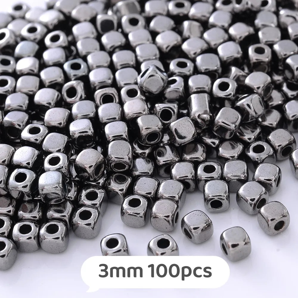 A pile of small, silver-colored geometric acrylic beads for jewelry making