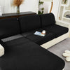 A black jacquard knit sofa cushion cover featuring a textured weave and light cream trim.