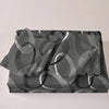 A set of three printed quilts featuring overlapping concentric circles in shades of gray and white.