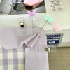 A set of colored sewing pins, including pink and green butterfly-shaped pins, displayed on a purple fabric.