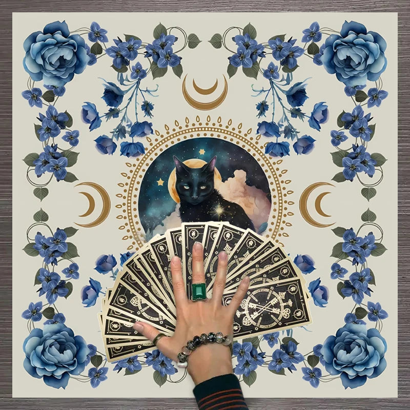 A hand holds a stack of tarot cards surrounded by blue and purple floral elements and crescent moons.