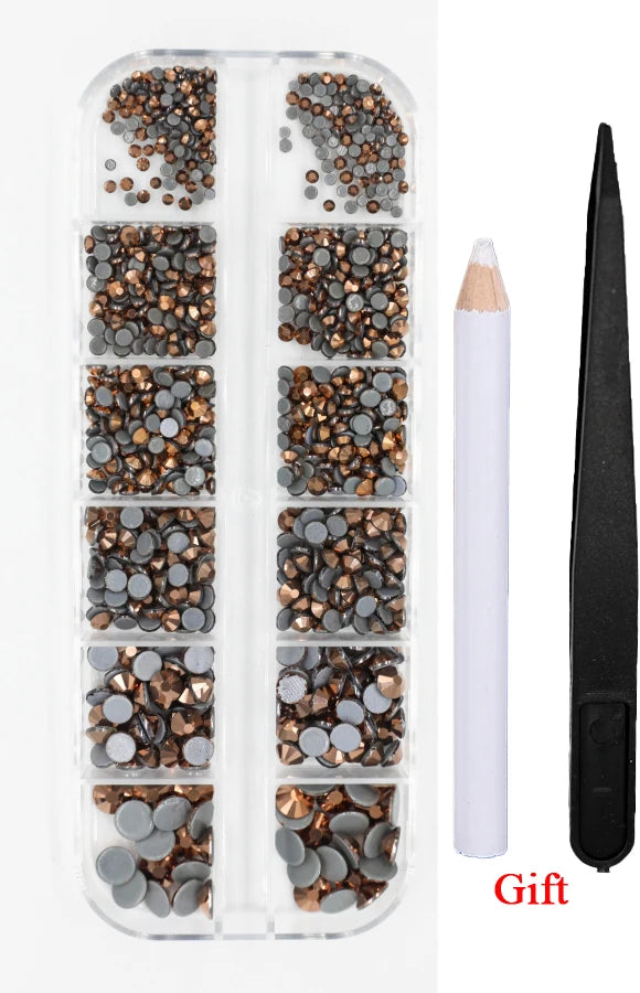 A clear plastic case containing multiple trays of crystal hot fix rhinestones and an applicator tool.