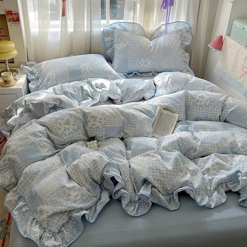 A light blue floral bedding set with a patterned duvet and pillows is displayed on a bed.