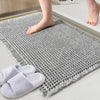 Gray waffle design non-slip bathroom mat with bare feet and slippers