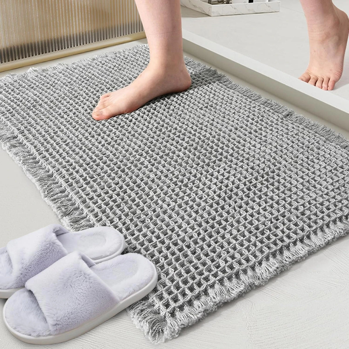 Gray waffle design non-slip bathroom mat with bare feet and slippers