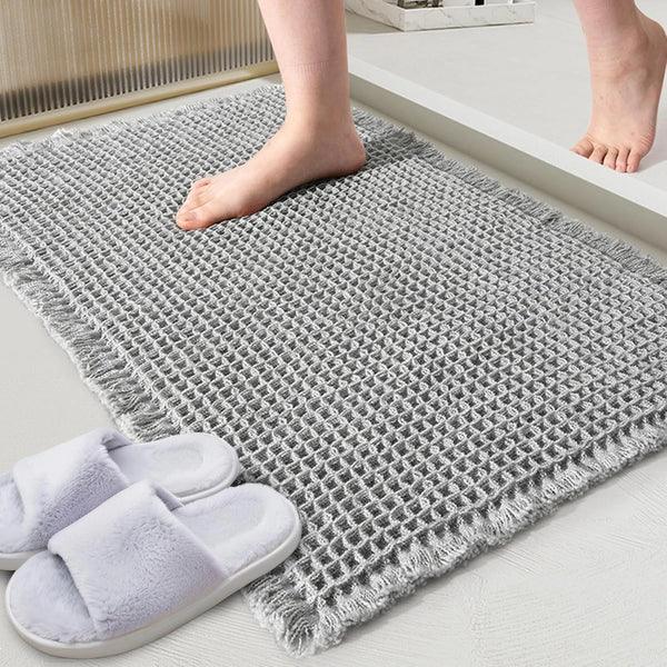 Gray waffle design non-slip bathroom mat with bare feet and slippers
