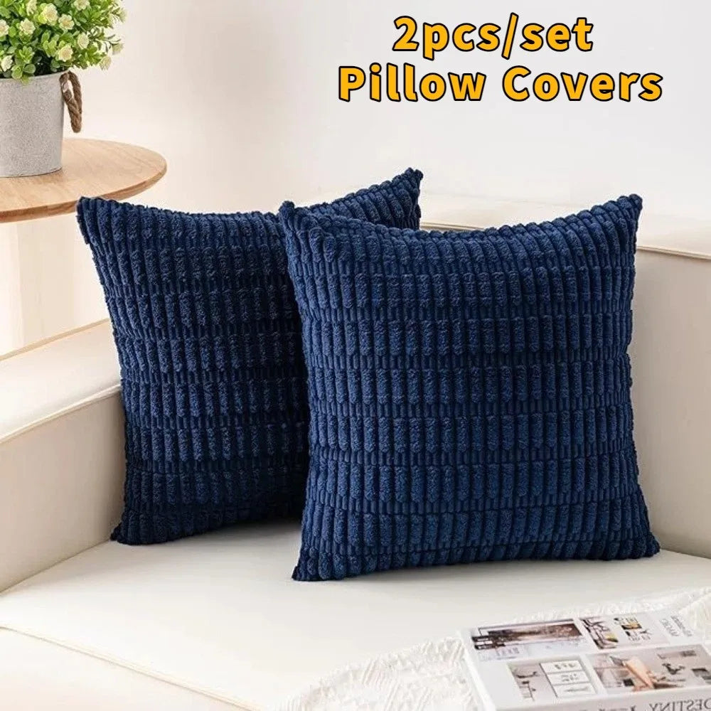 A set of two dark navy blue knitted pillow covers with a textured pattern displayed on a white surface.