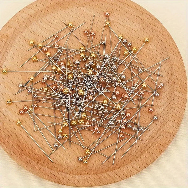 A scattering of silver and gold precision positioning pins spread across a wooden surface.