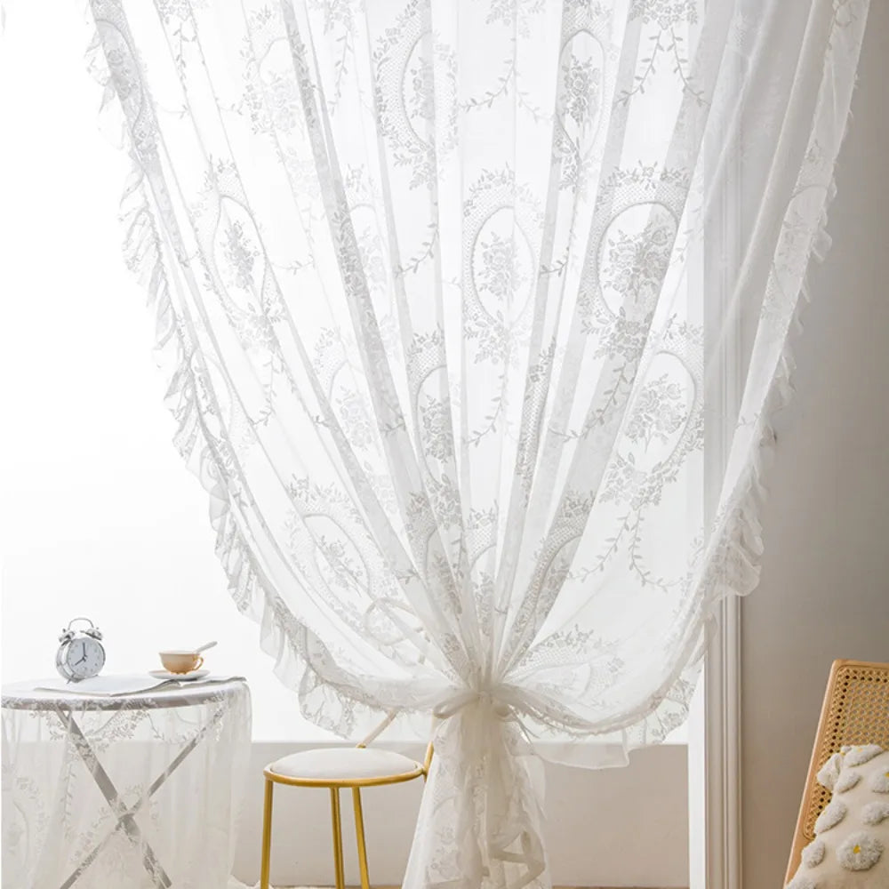 White sheer curtain with floral lace pattern draped in a window