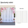 White tulle backdrop curtains with pink floral accents shown in a draped style.