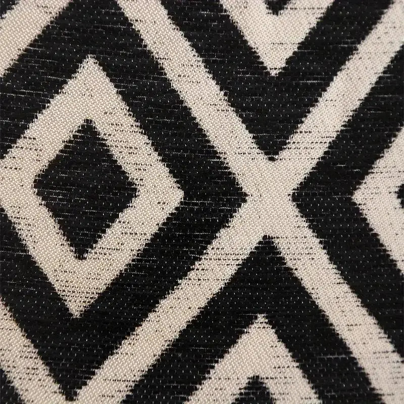 Close-up of a black and cream chenille jacquard fabric with an intersecting diamond pattern.
