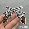 Iron-on patches of Western cowboy guns crossed on a hand