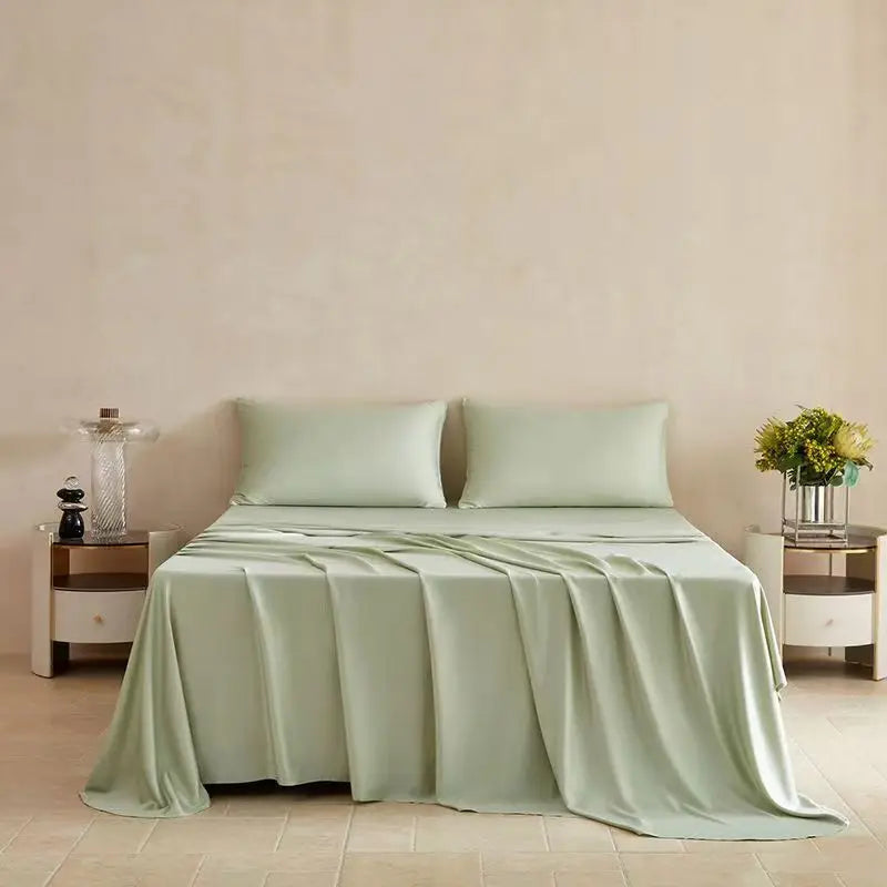 A light sage green flat bed sheet draped over a bed in a minimalist room with natural light.