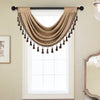 A beige European style window curtain valance with tassels hanging over a white-framed window.