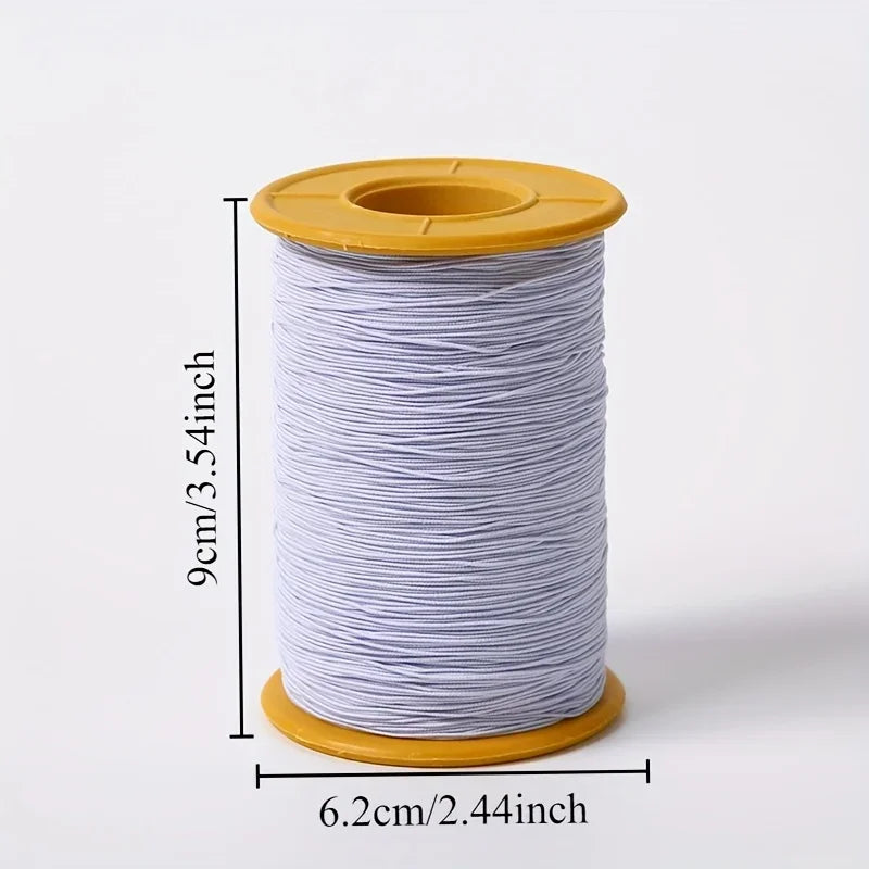 A spool of white elastic sewing thread with a yellow plastic core and cap.
