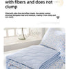 A light blue quilted quilt set with a floral pattern is displayed on a bed.