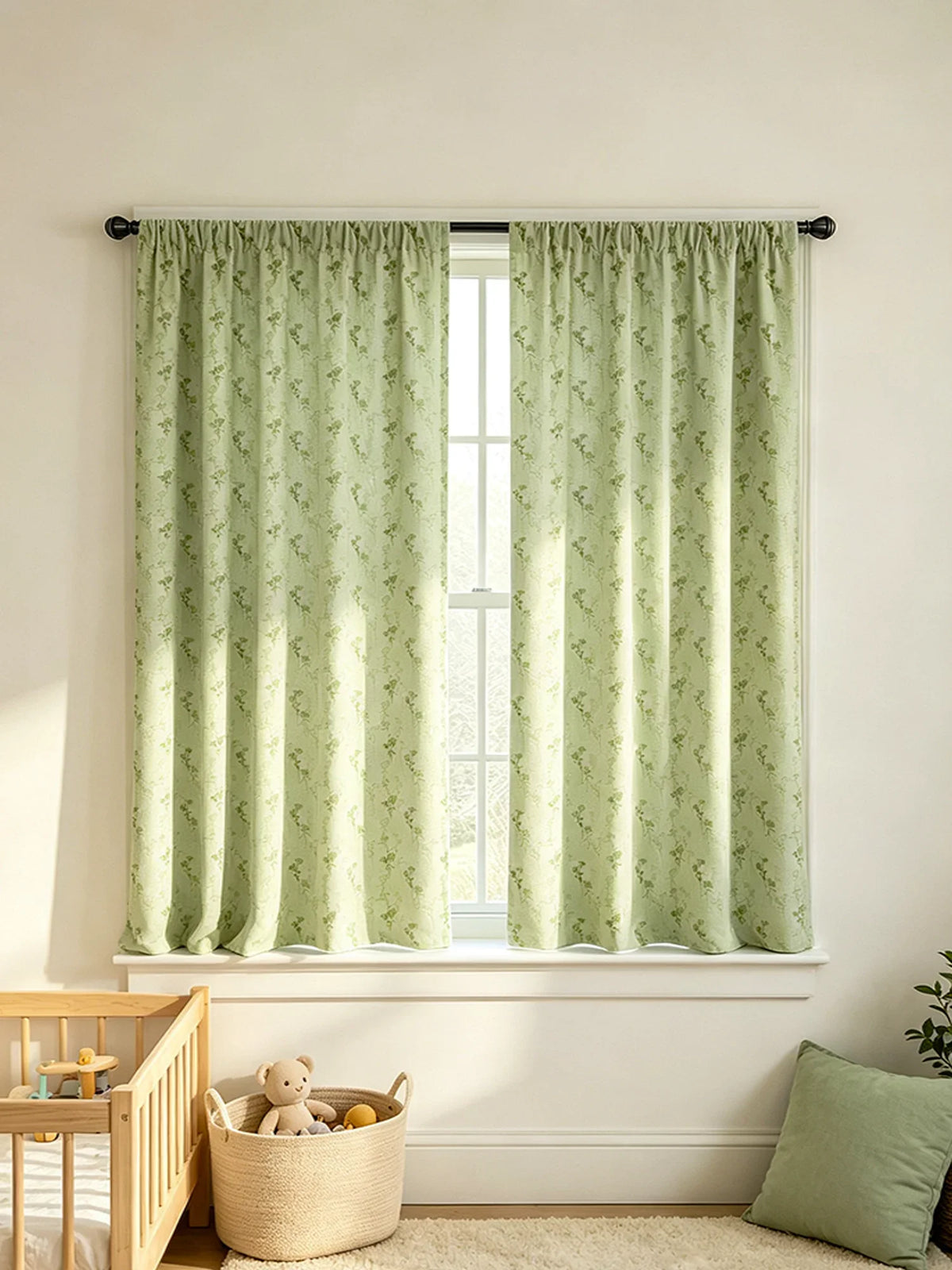 A pair of light green floral print curtains hanging in a window with white trim and a wooden furniture piece nearby.