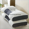 A white quilted neck support pillow with gray accents resting on a light surface.