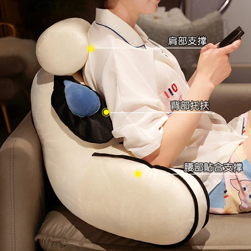 A person is using a plush sofa cushion with various support points marked on the back and head.