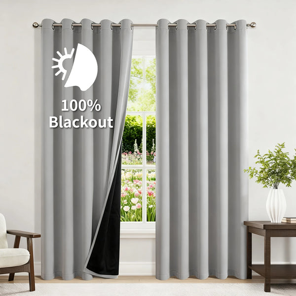 Gray blackout thermal window drapes hanging in a window frame.