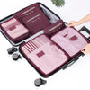 A set of six purple and pink laundry pouches organized inside a black storage organizer case.