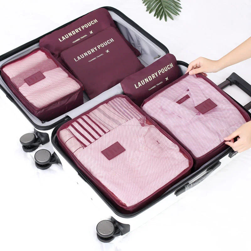 A set of six purple and pink laundry pouches organized inside a black storage organizer case.