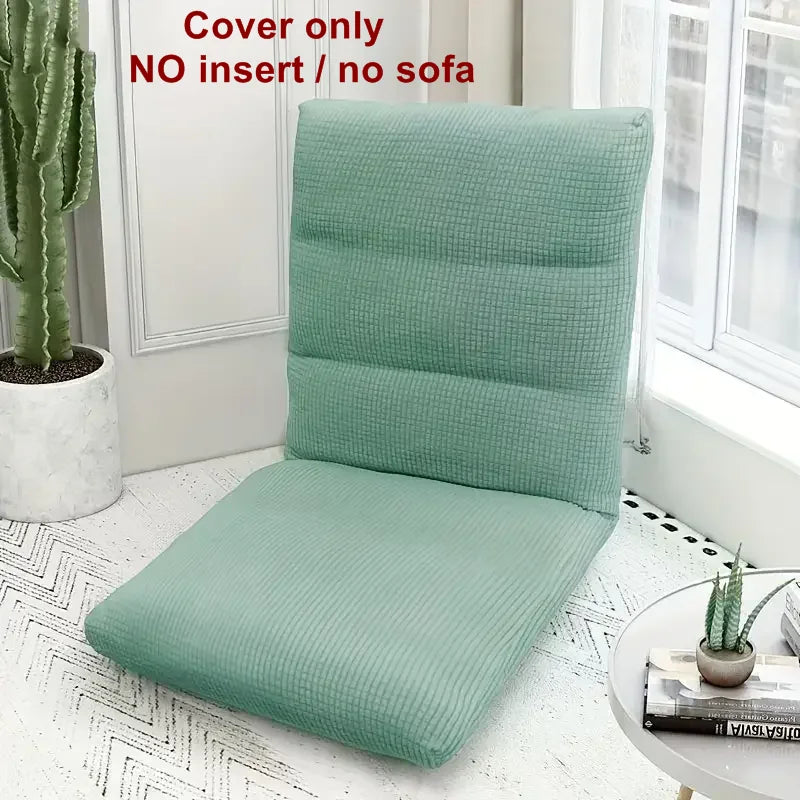 A light green folding tatami seat cover placed on a white floor, next to a window and a potted cactus.